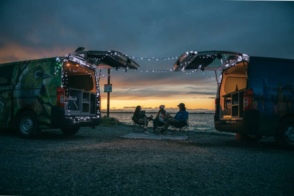 Settling in for the night at a beach campsite in campervans. 