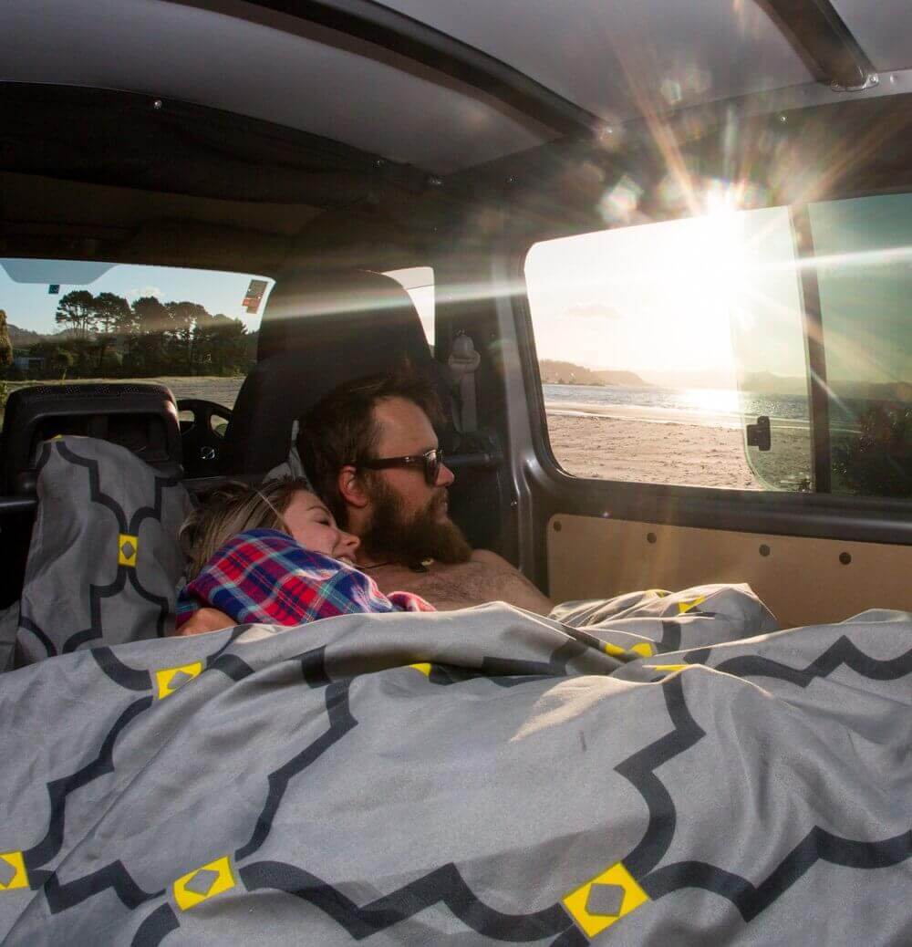 Queen size bed inside a campervan