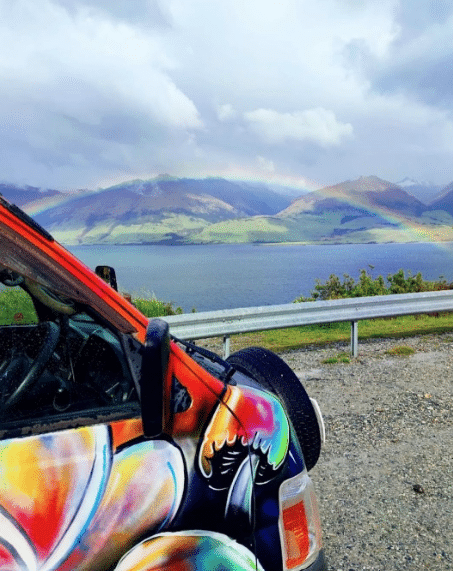 Escape Rentals rainbow Escape Rentals campervan overlooking mountain and lake view with rainbow