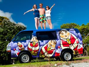 Travellers on top of a Escape Rentals campervan