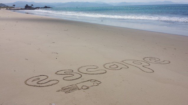 escape written on beachsand